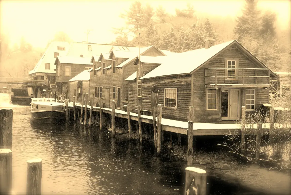 The Leland River in winter, edged by snow and waterfront buildings