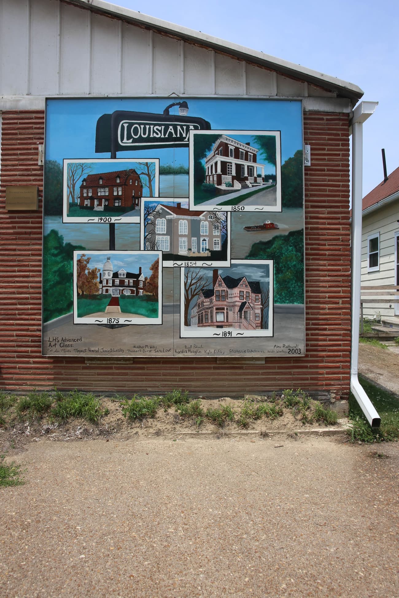 A large outdoor mural painted on a downtown brick wall in Louisiana, Missouri.