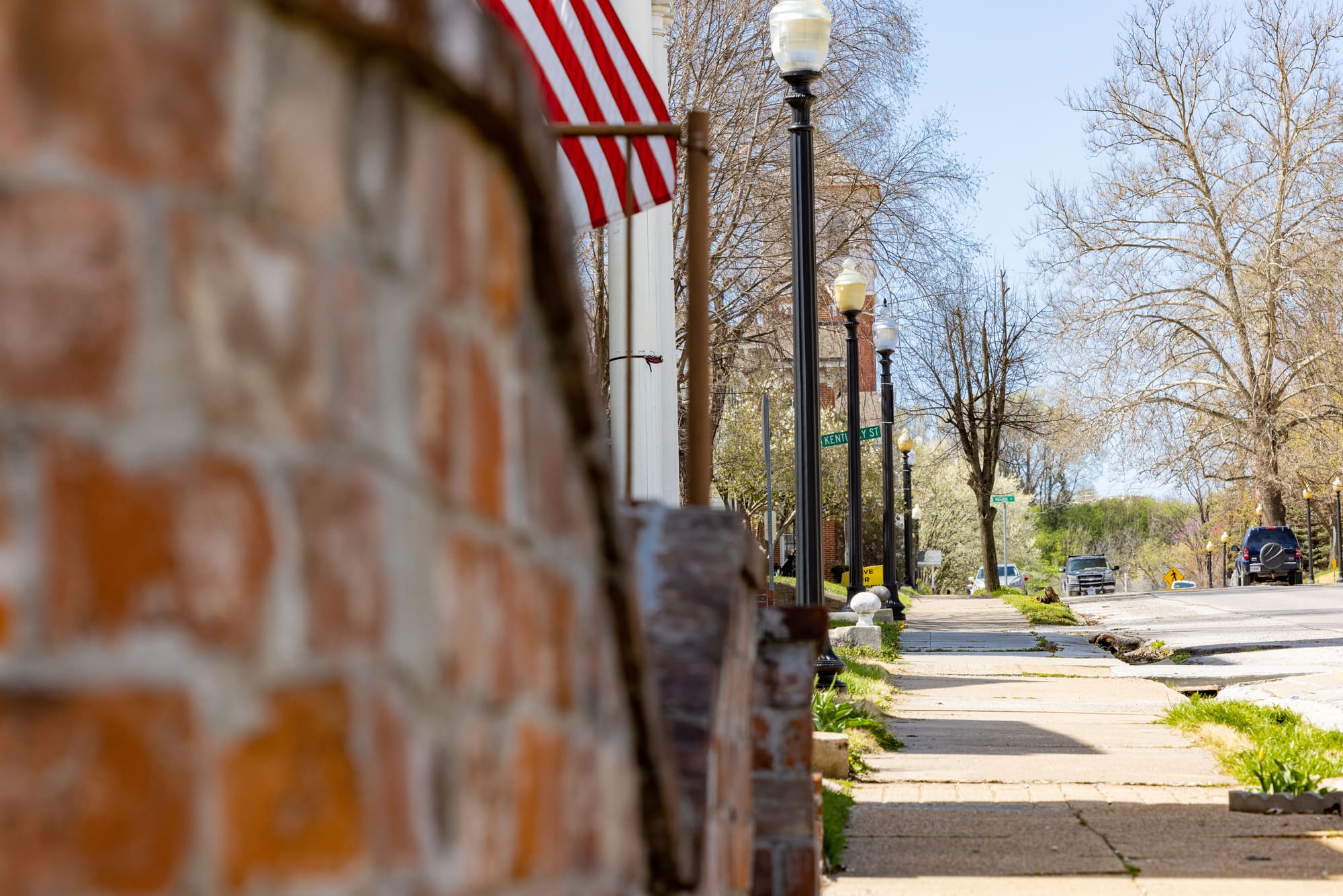 A brick sidewalk and American flag along Georgia Street in downtown Louisiana.