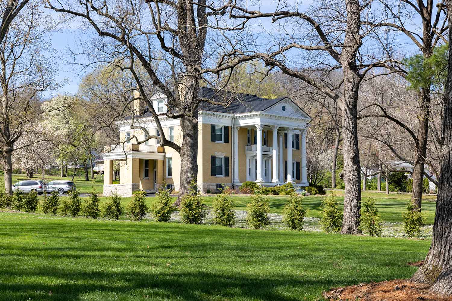 A white colonial-revival house and grounds in one of Louisiana's historic residential neighborhoods.