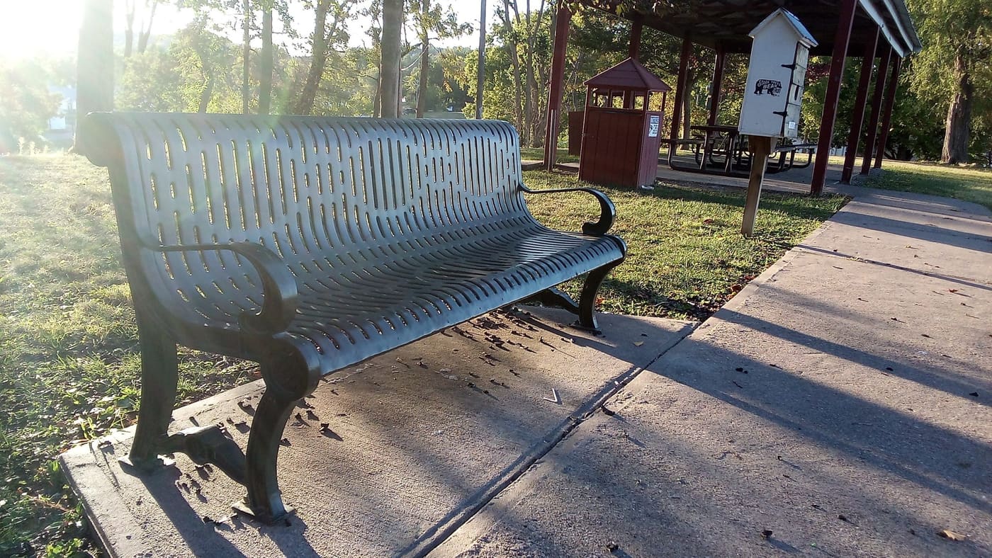 A park bench at golden hour in Riverview Park.