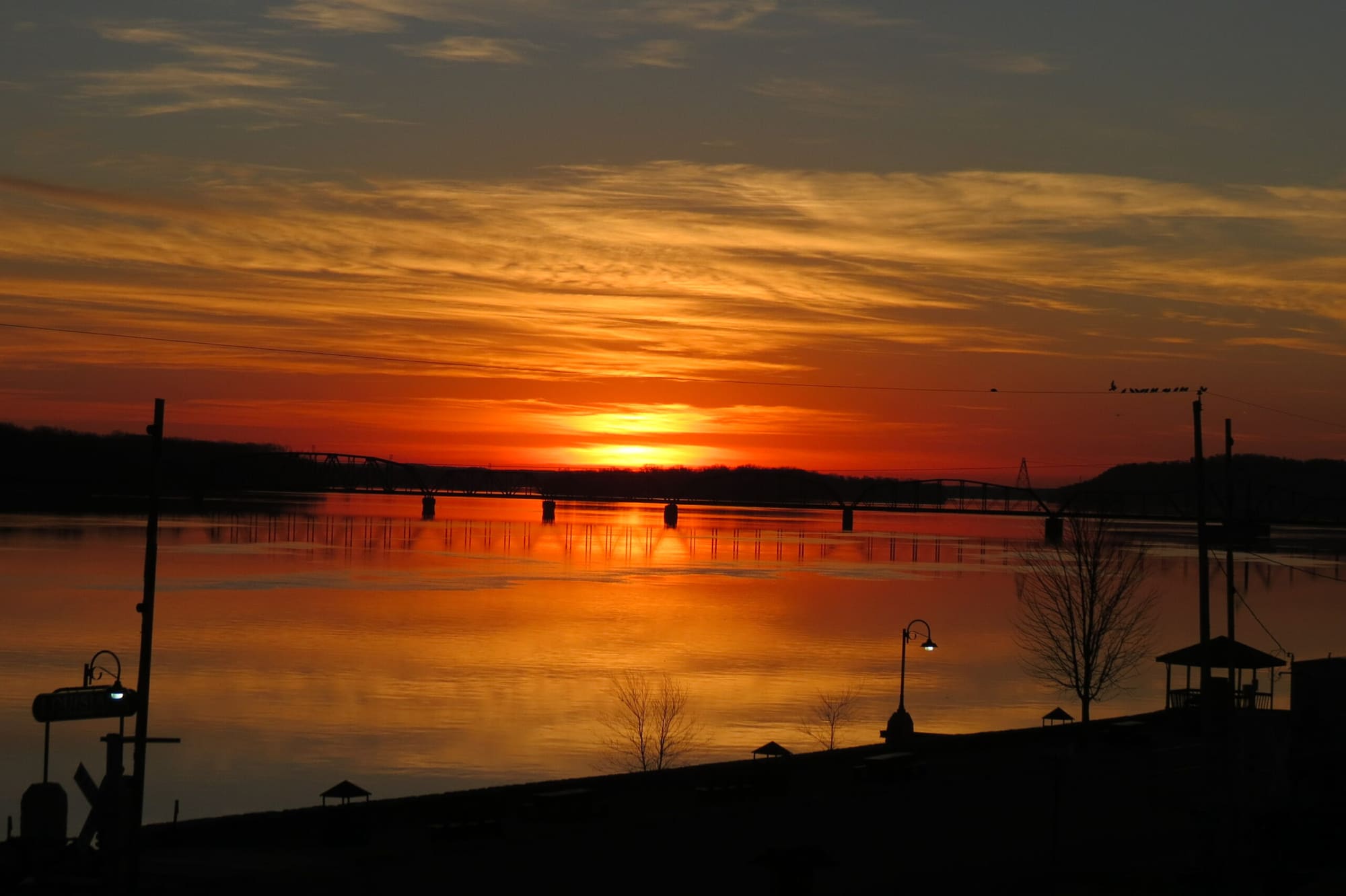 Sunrise over the Mississippi River at Louisiana, Missouri, with the railroad bridge crossing the water in the distance.