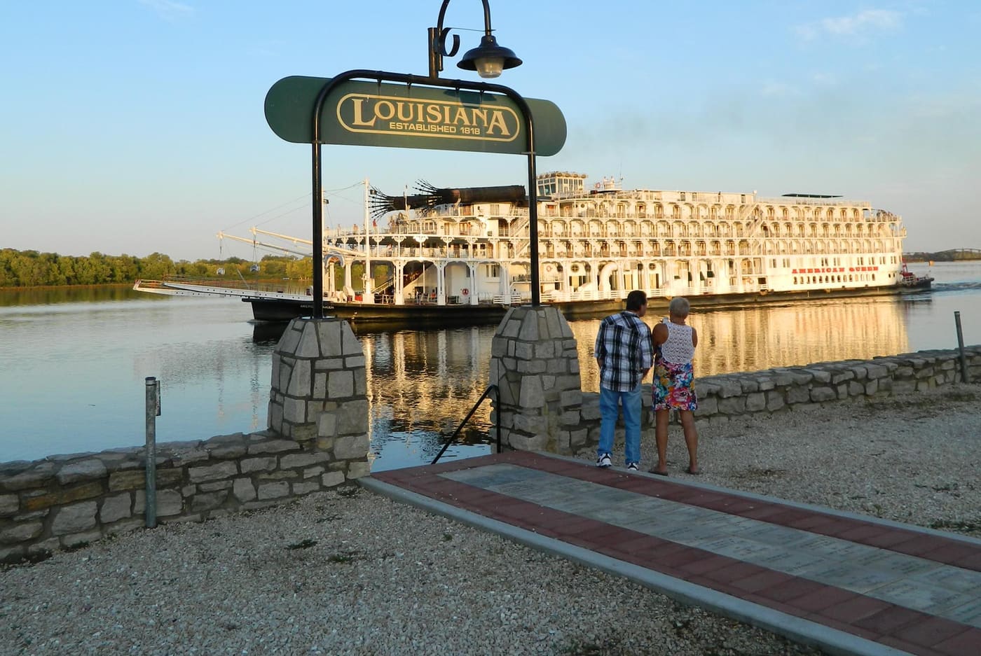 A riverboat docked near the Louisiana welcome sign on the Mississippi River.