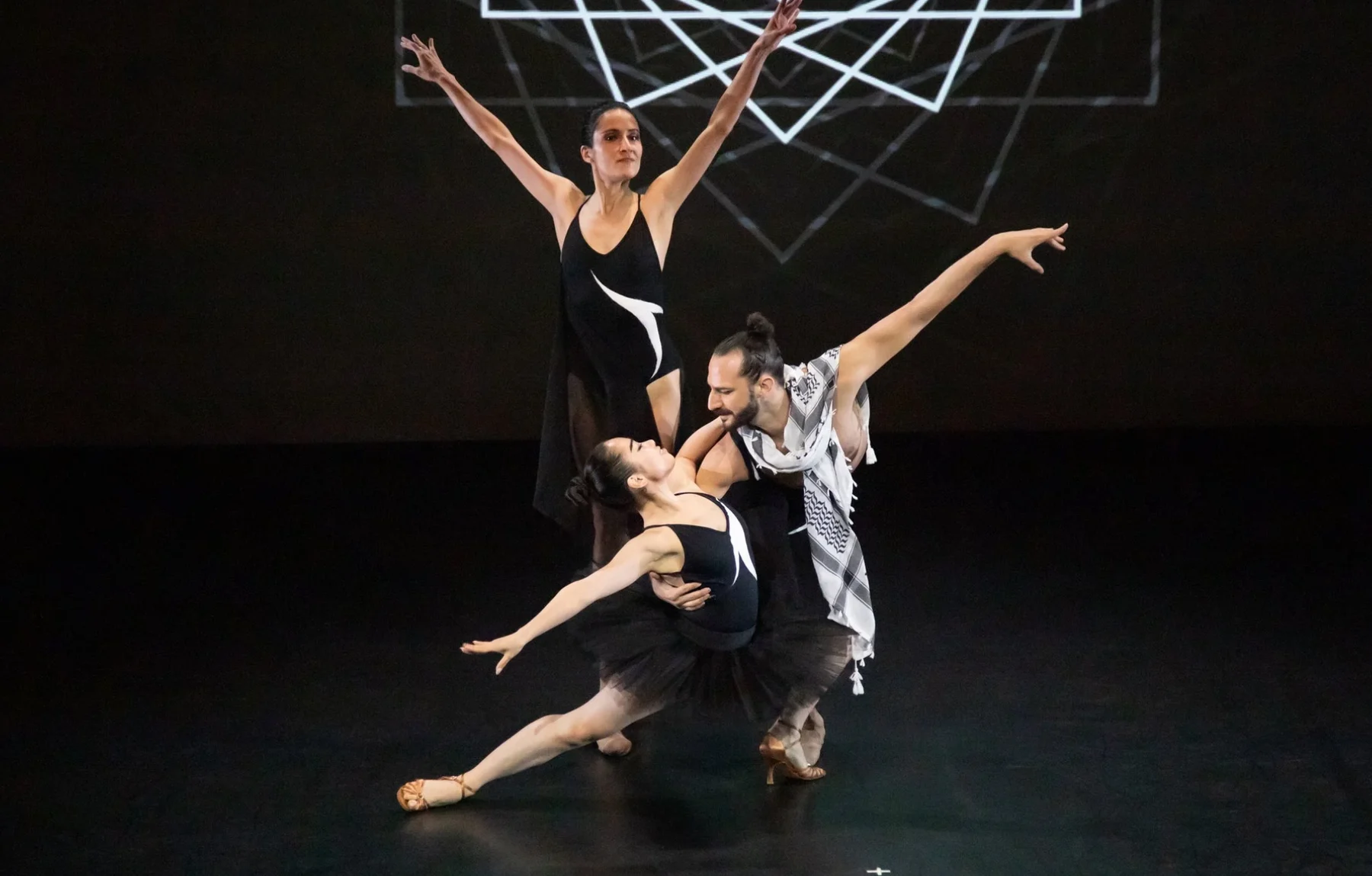 Four FJK Dance performers form a sculptural group onstage.