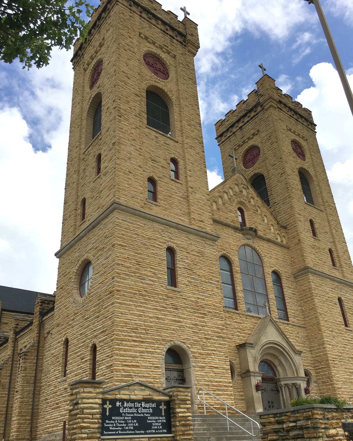 The twin limestone towers of St. John's Catholic Church against the sky
