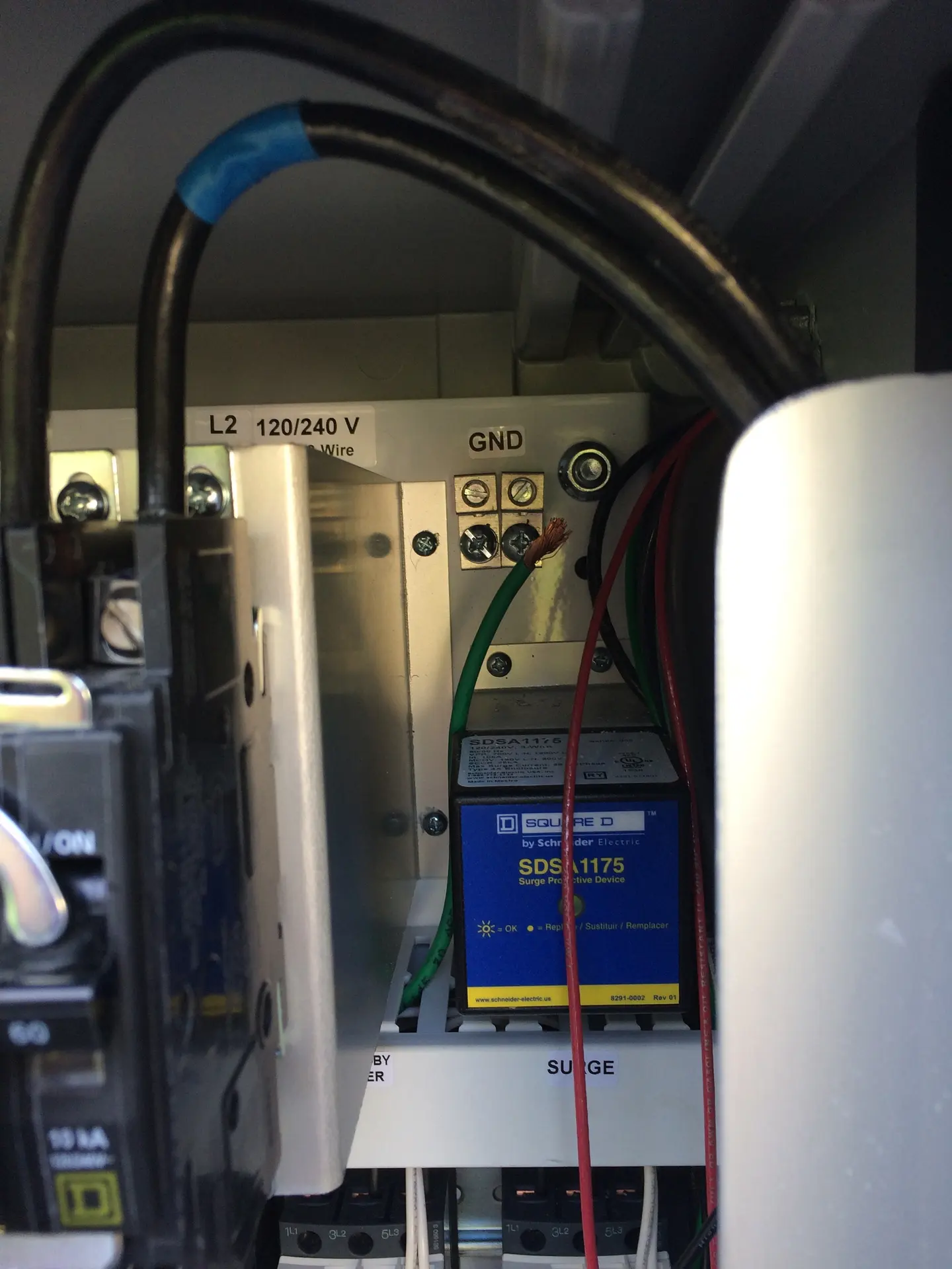 An open electrical control cabinet beside process equipment