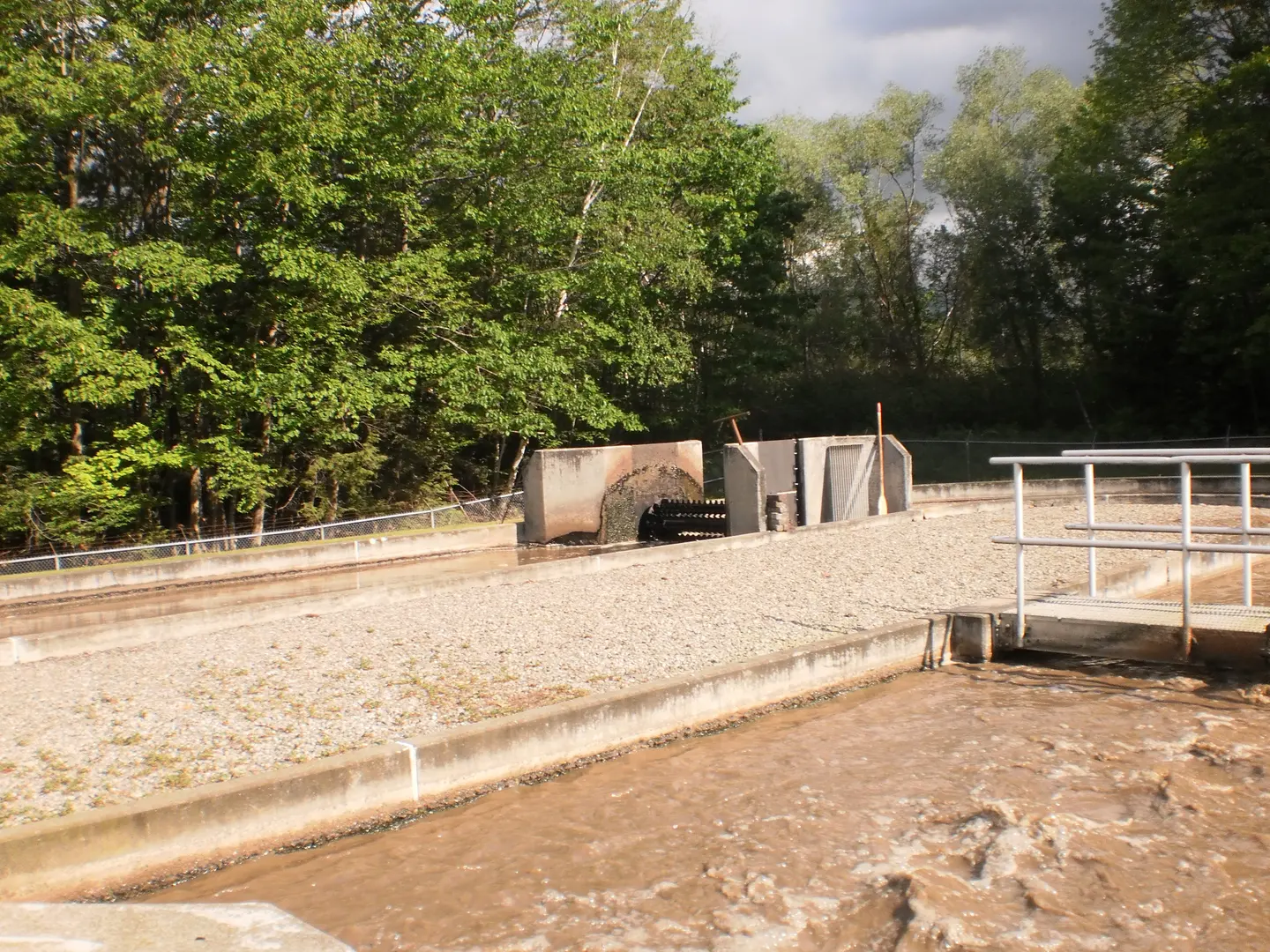 Sand treatment beds with concrete walls, trees behind