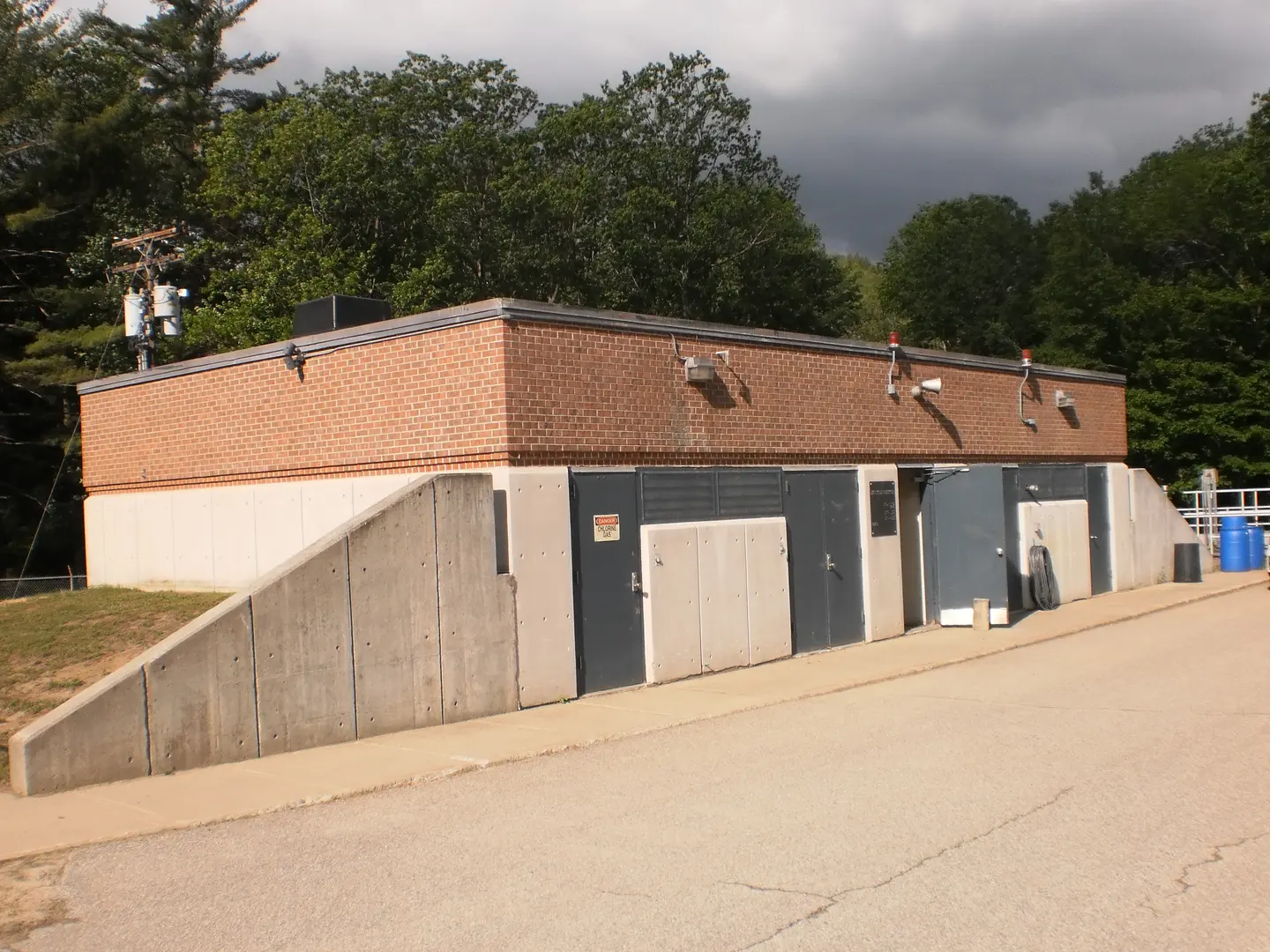 A low brick treatment plant building under a gray sky