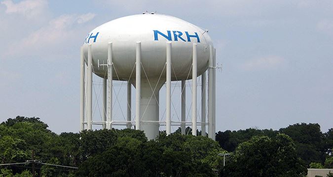 The North Richland Hills NRH water tower above the tree line