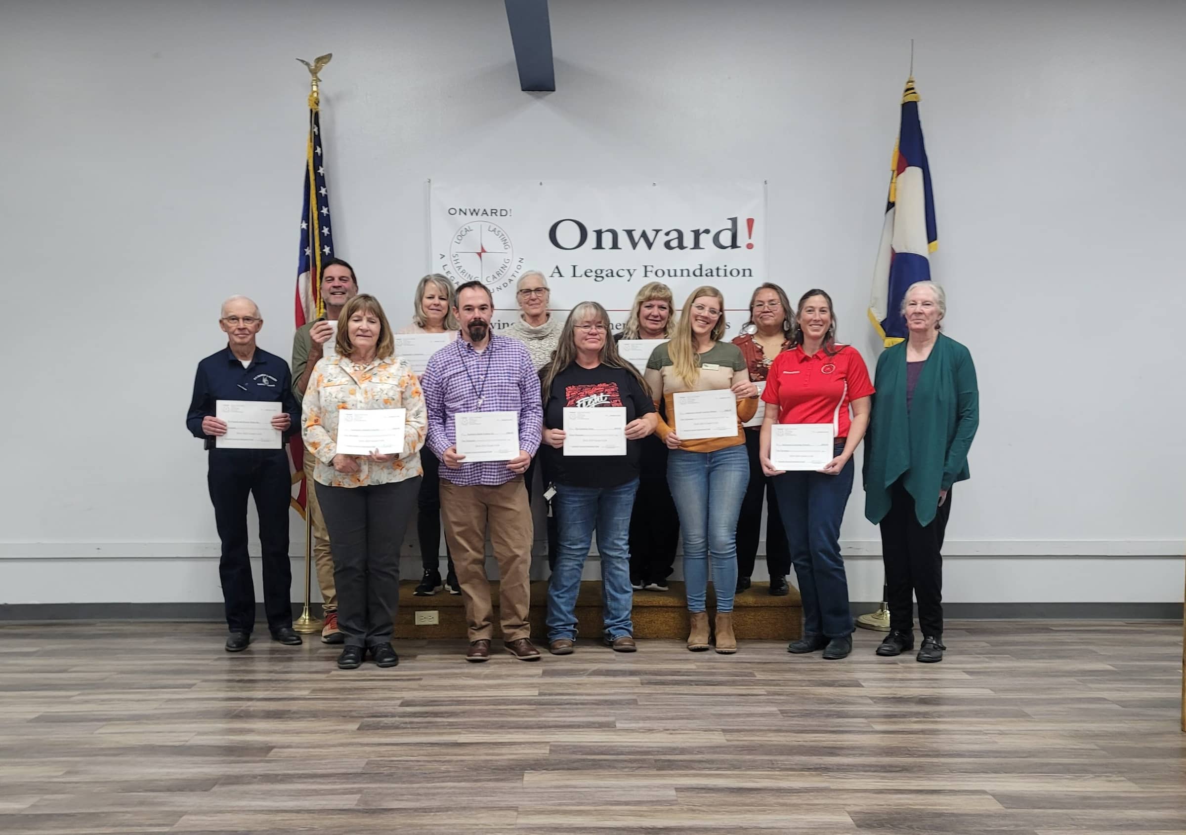 2024 General Endowment Fund grant awardees holding their certificates in front of the Onward! banner