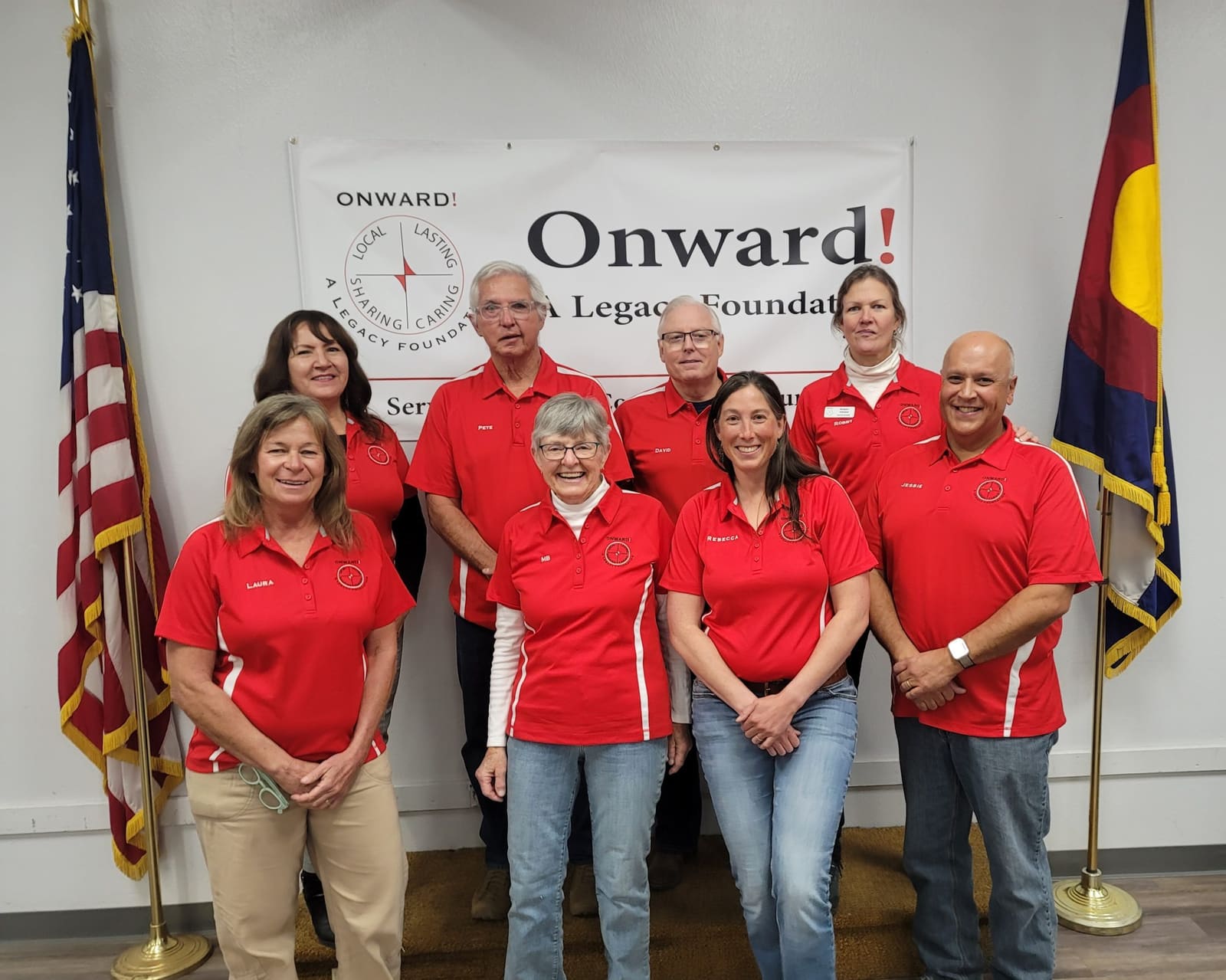 The Onward! board in red polos in front of the Onward! banner, 2023