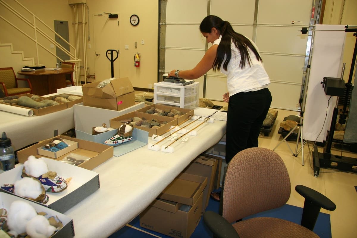 A staff member cataloguing artifacts on a work table in the curation room