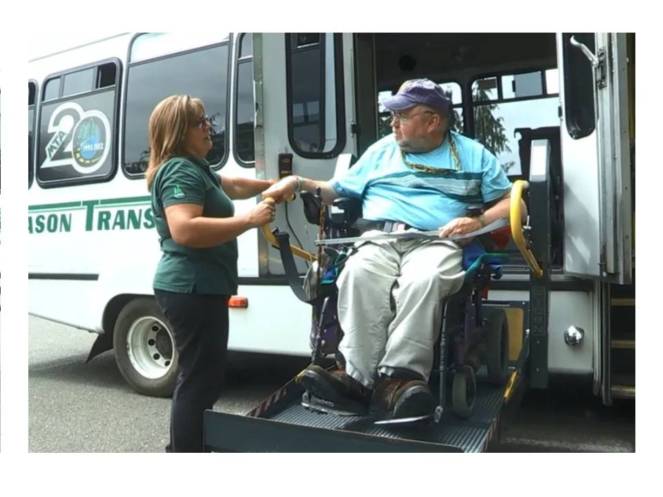 A Mason Transit driver helps a rider in a wheelchair on the bus lift.