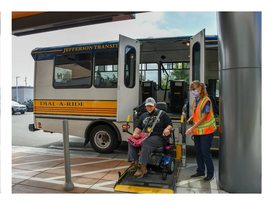 A Jefferson Transit Dial-a-Ride attendant helps a rider in a power wheelchair on the lift.