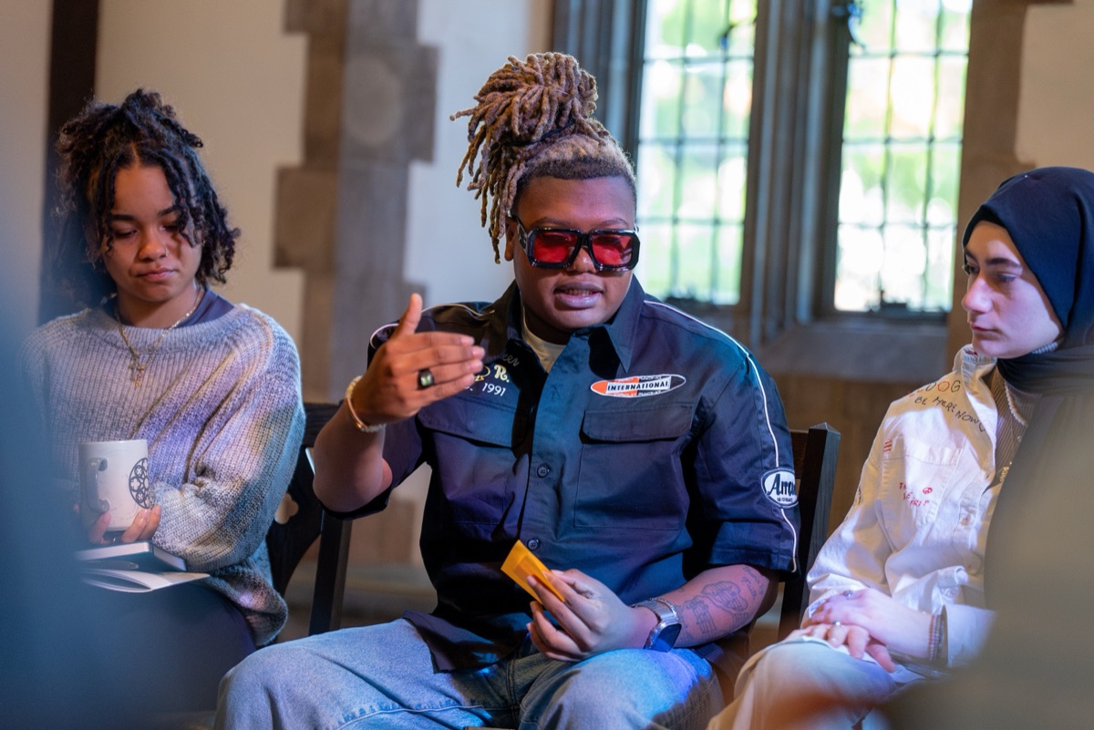 A small conversation circle beneath a Gothic stone window during a Building Community session