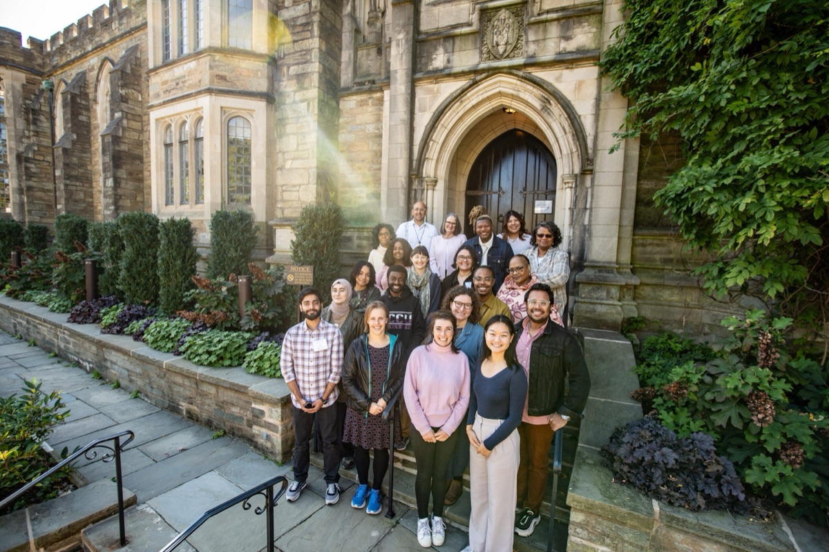 An Auburn Theological Seminary cohort gathered on stone chapel steps at golden hour, part of a PSR Collective partner course