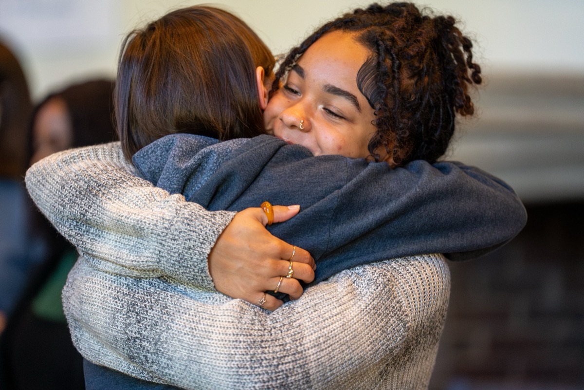 Two participants embrace at a community gathering
