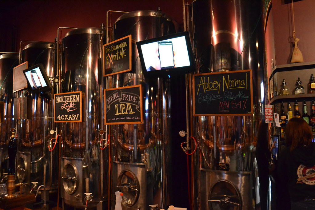 The wood-and-brick taproom of the Royal Oak Brewery, tables set under warm pendant lights