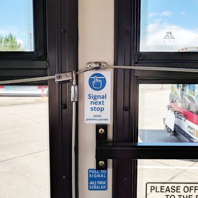 The front door of a Cherriots bus with the pull cord and Signal Next Stop instructions