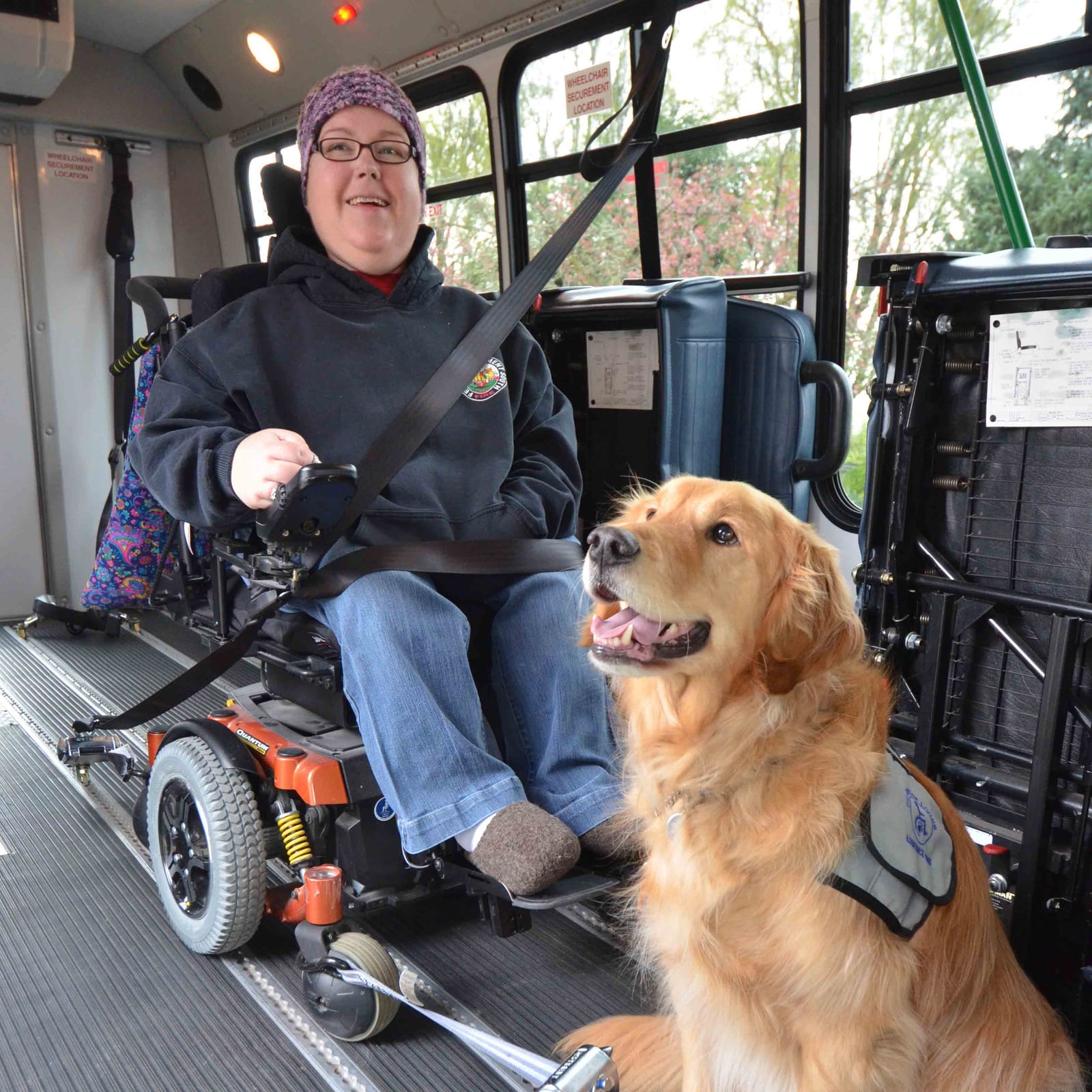 A LIFT rider in a power wheelchair aboard the van, her service dog beside her