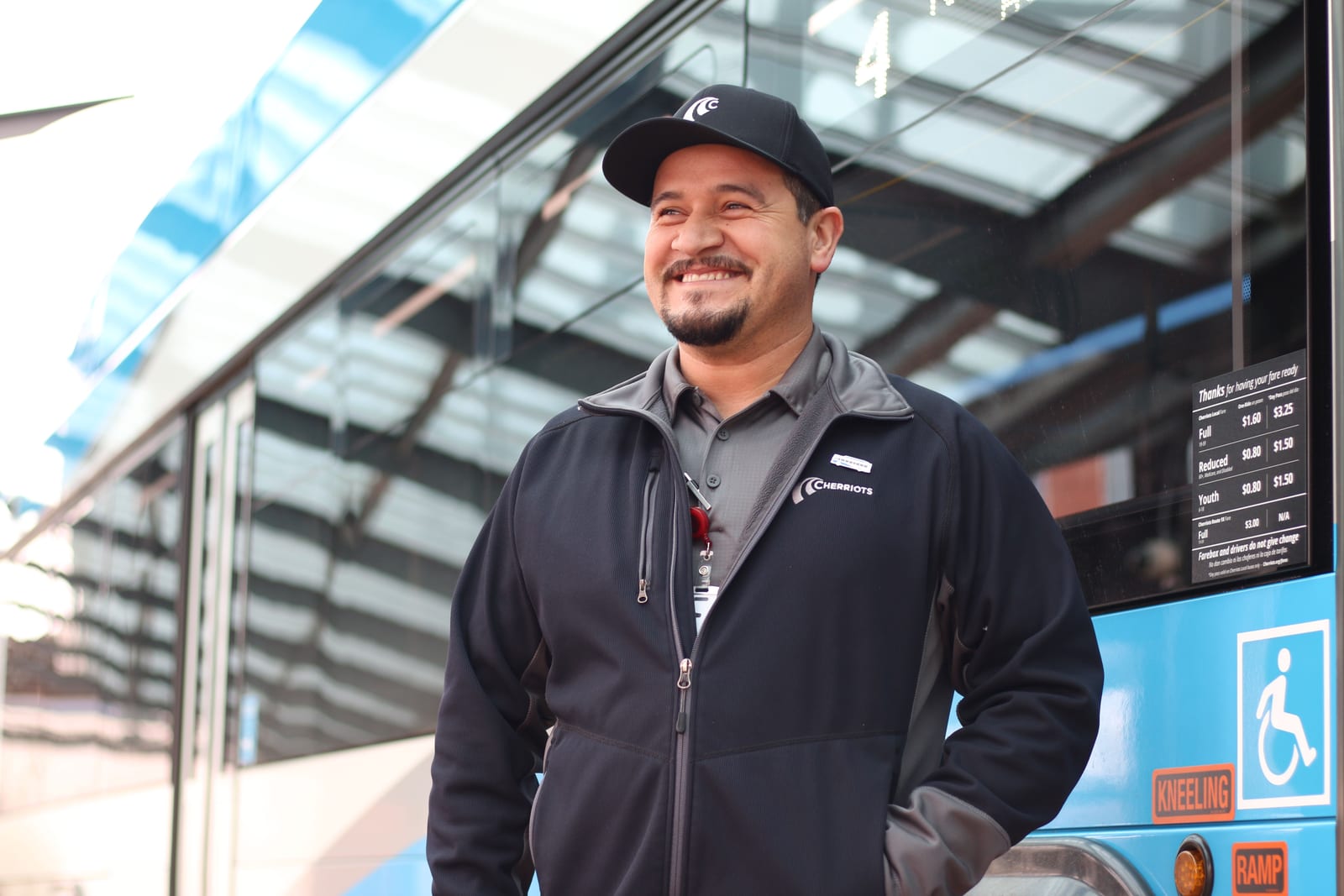 A smiling Cherriots operator at a transit center shelter