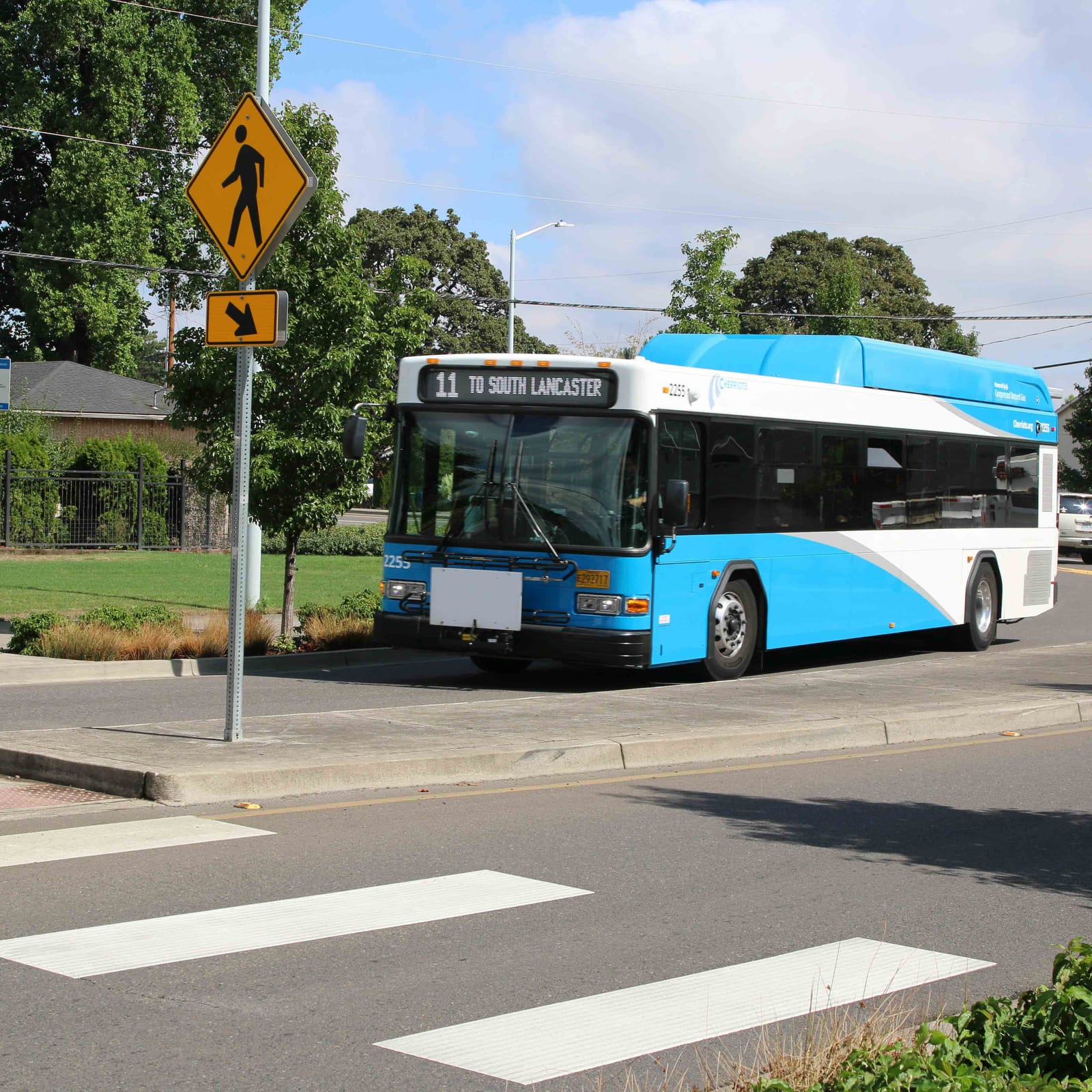 A Cherriots Local bus crossing a Salem intersection under signal lights