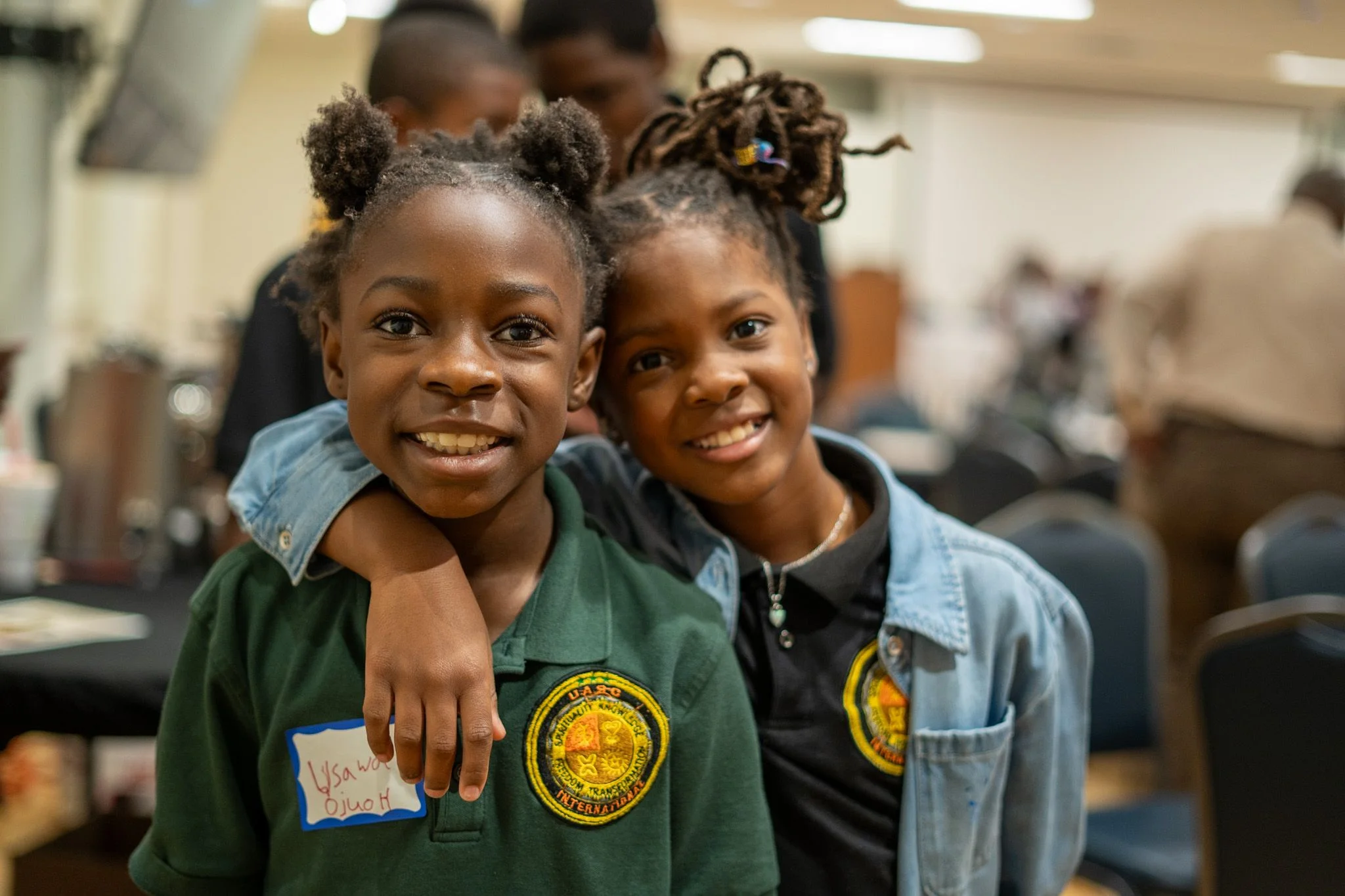 Two young people smile together at an event.