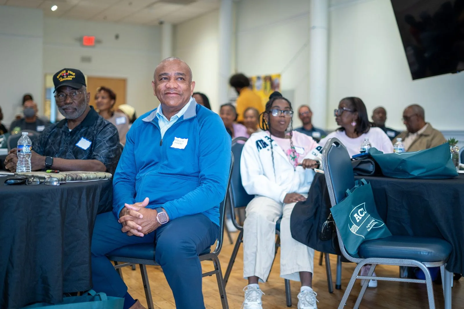 People sit together in the audience at a South Carolina Black Farmers Coalition event.