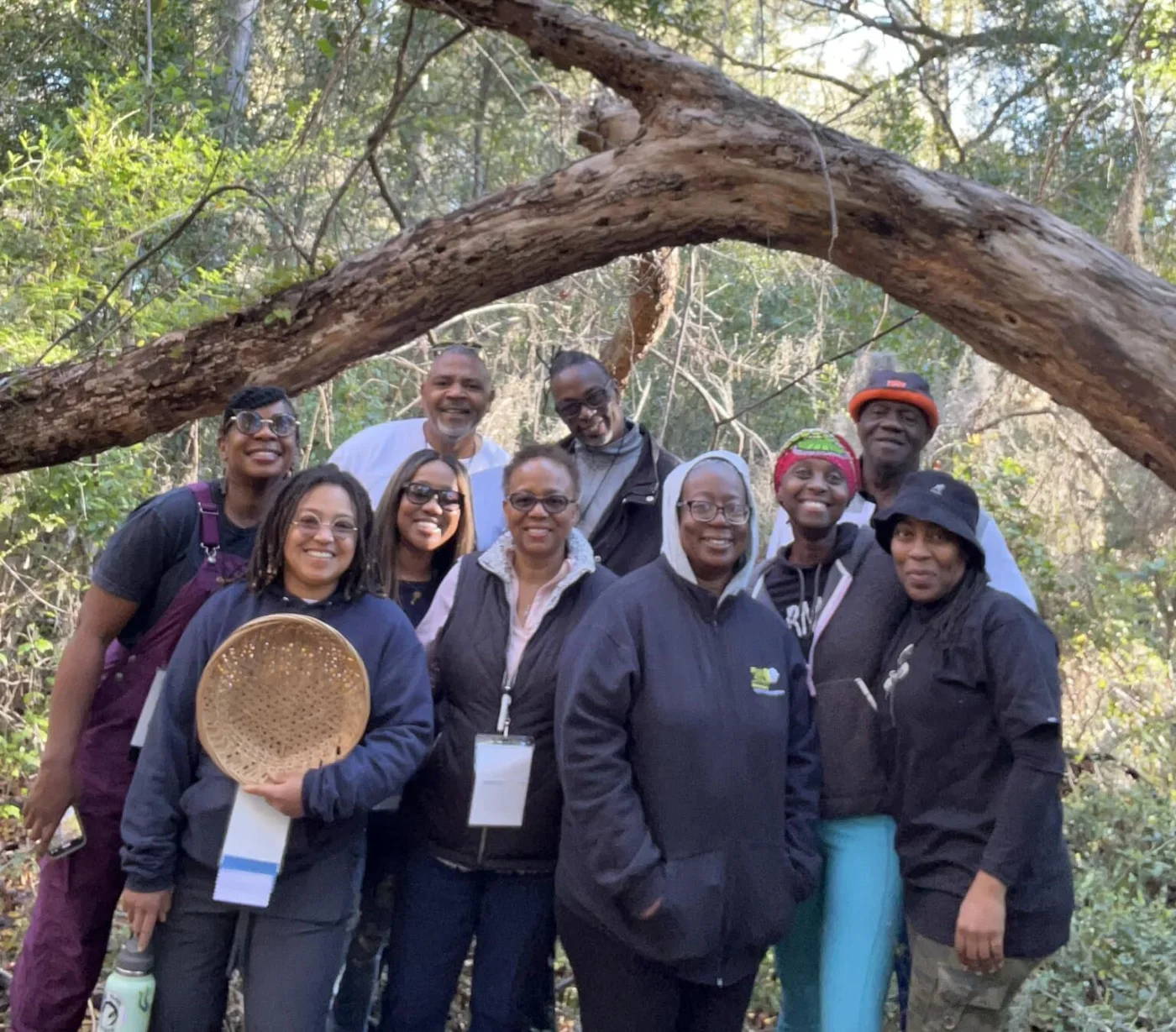 A group gathers beneath a large live oak during a nature walk.