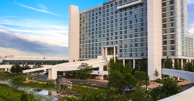 The Renaissance Schaumburg Convention Center Hotel tower rising behind landscaped ponds