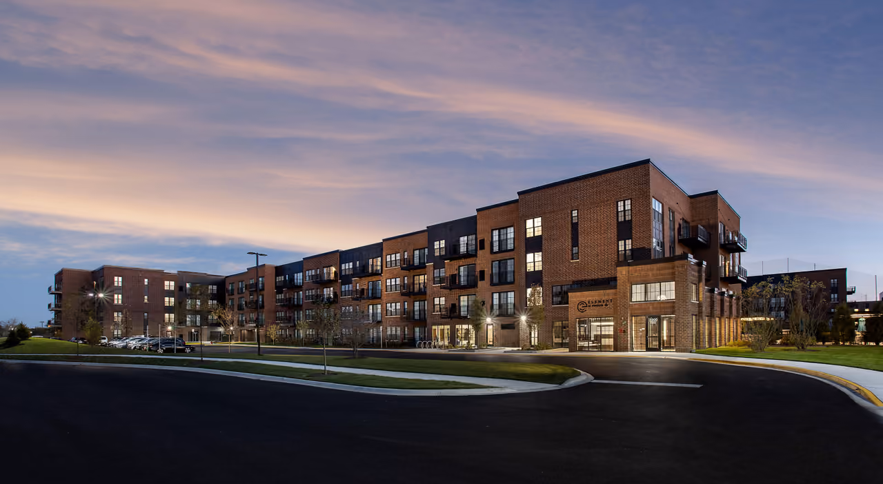 The Element apartment buildings at dusk, windows lit under a purple sky