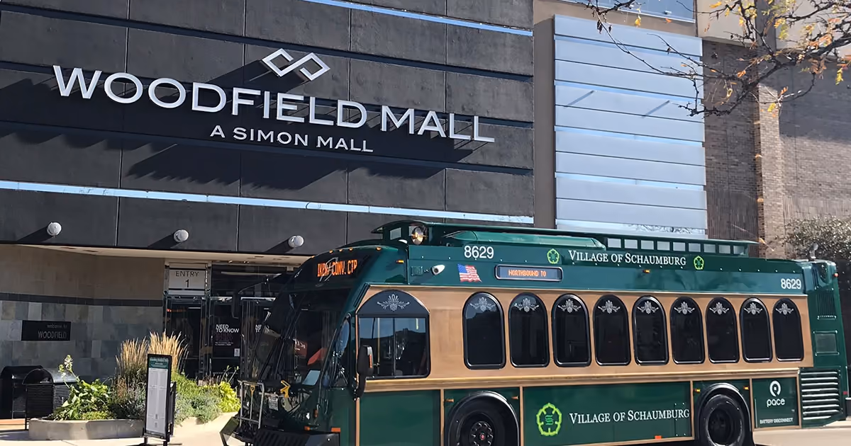 A green Village of Schaumburg trolley parked at the Woodfield Mall entrance