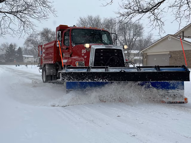 A Village of Schaumburg snow plow clears snow from a road