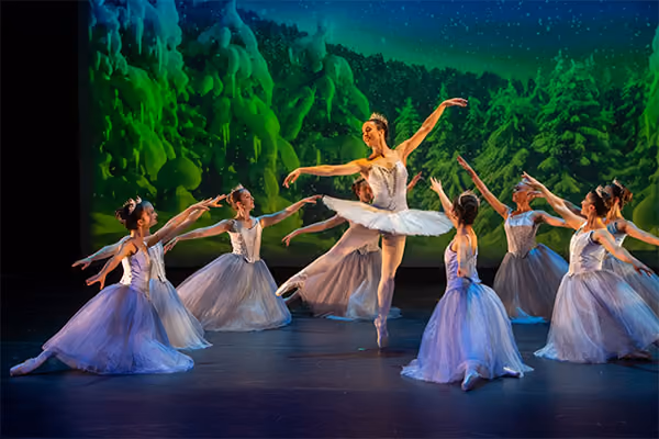 Dancers in white tutus performing the snow scene from The Nutcracker