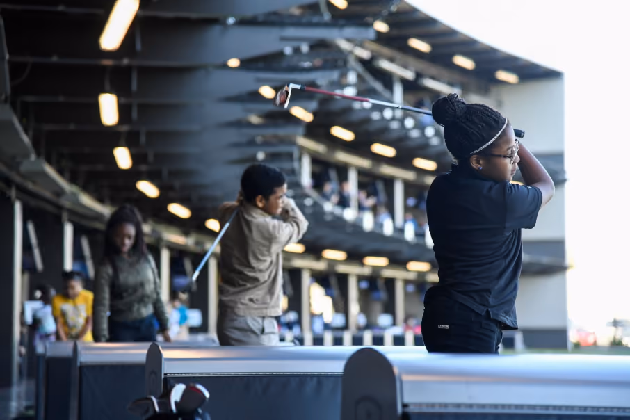 A close-up of patrons enjoying Topgolf Schaumburg's climate-controlled, interactive golf bays.