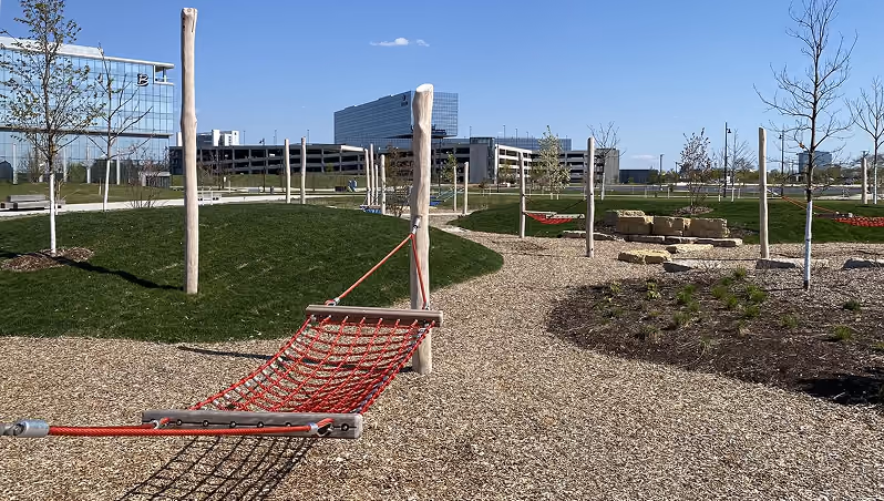 A rope hammock beside a gravel path in 90 North Park, office buildings beyond