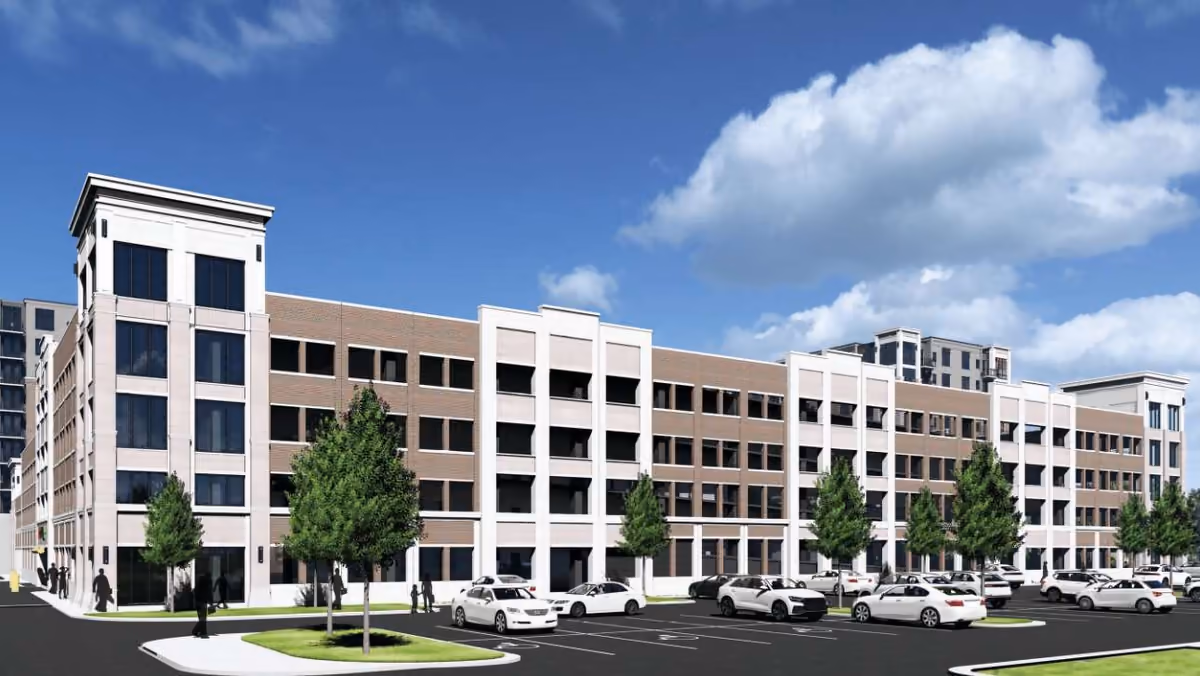 A rendering of a mid-rise apartment building above a tree-lined parking lot