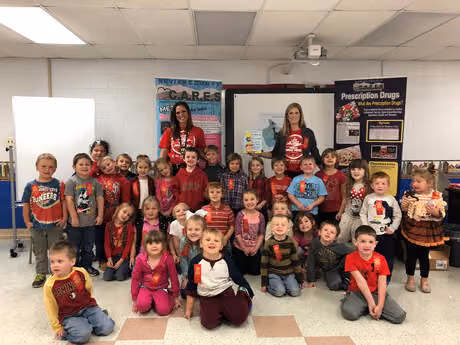 A class of young students with three adults in their classroom