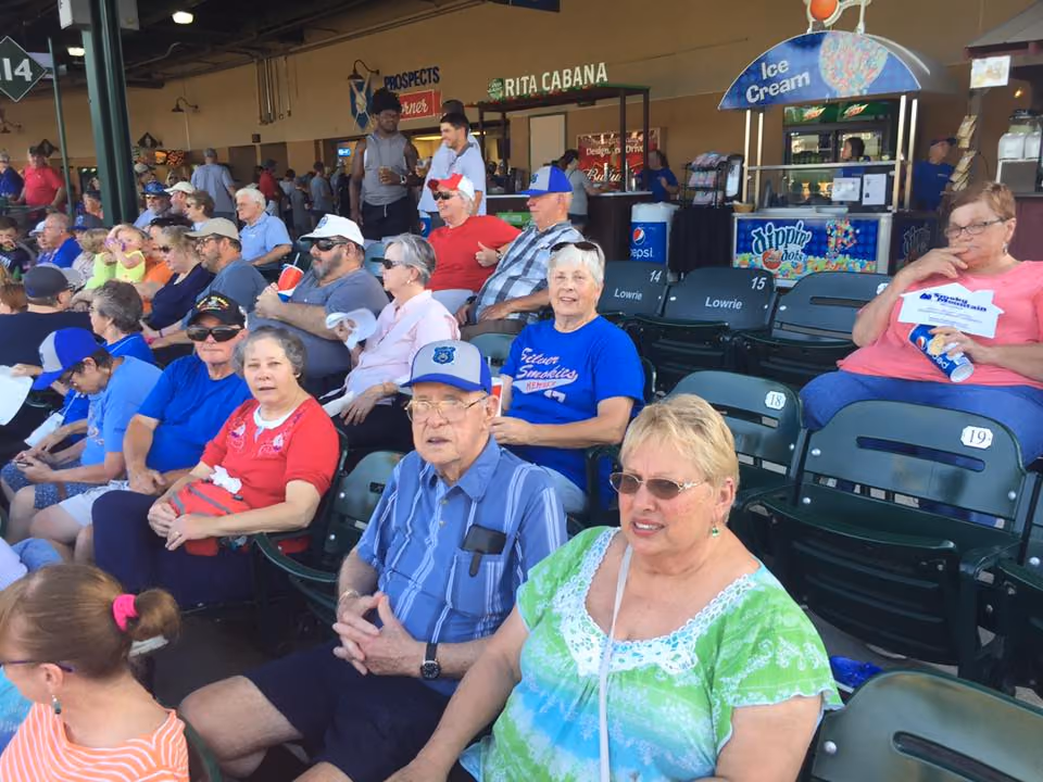 Seniors in red, white and blue in the stands at a ballpark