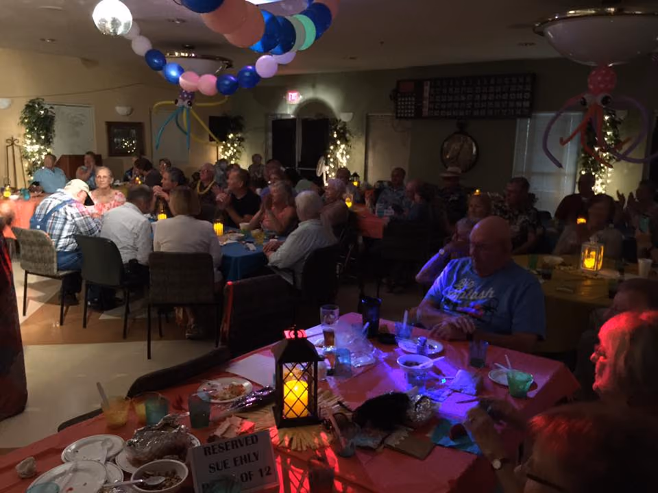 Seniors at a party under balloons, lanterns lit on the tables