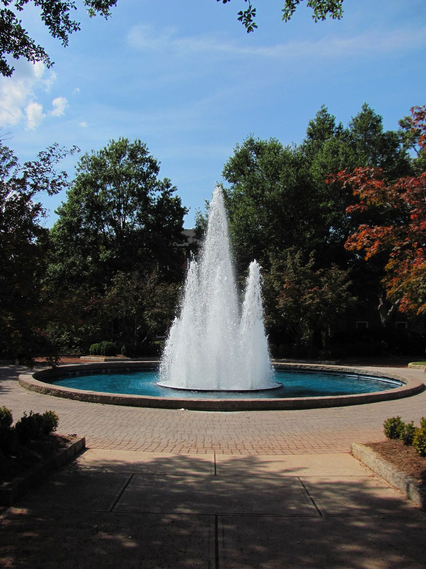 The fountain at Herty Field on North Campus, surrounded by lawn and trees