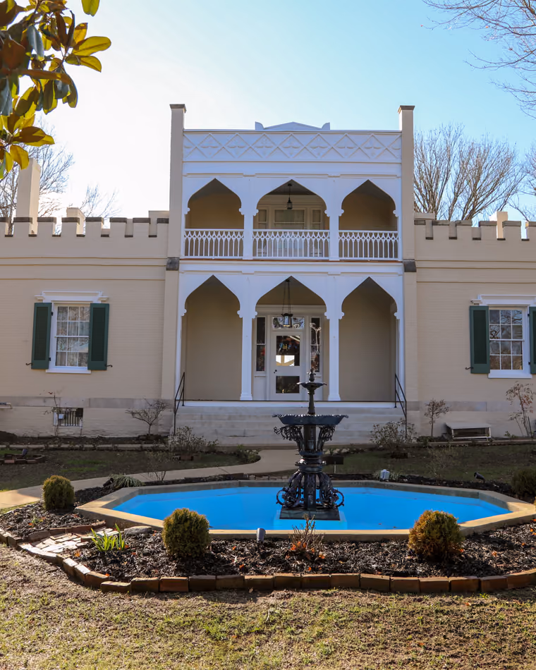 The Athenaeum's cream Moorish-style front with a fountain on its lawn.