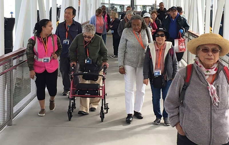 Older adults and travel-training participants walking together at a transit station