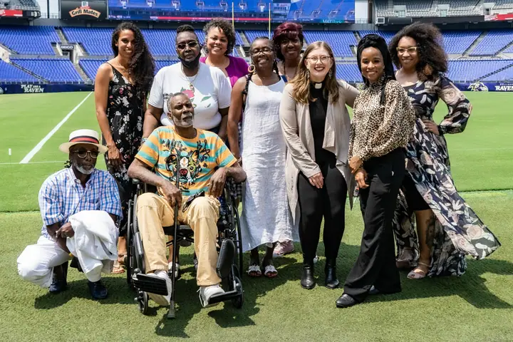 Weaver Awardees stand together on the green field of a football stadium.