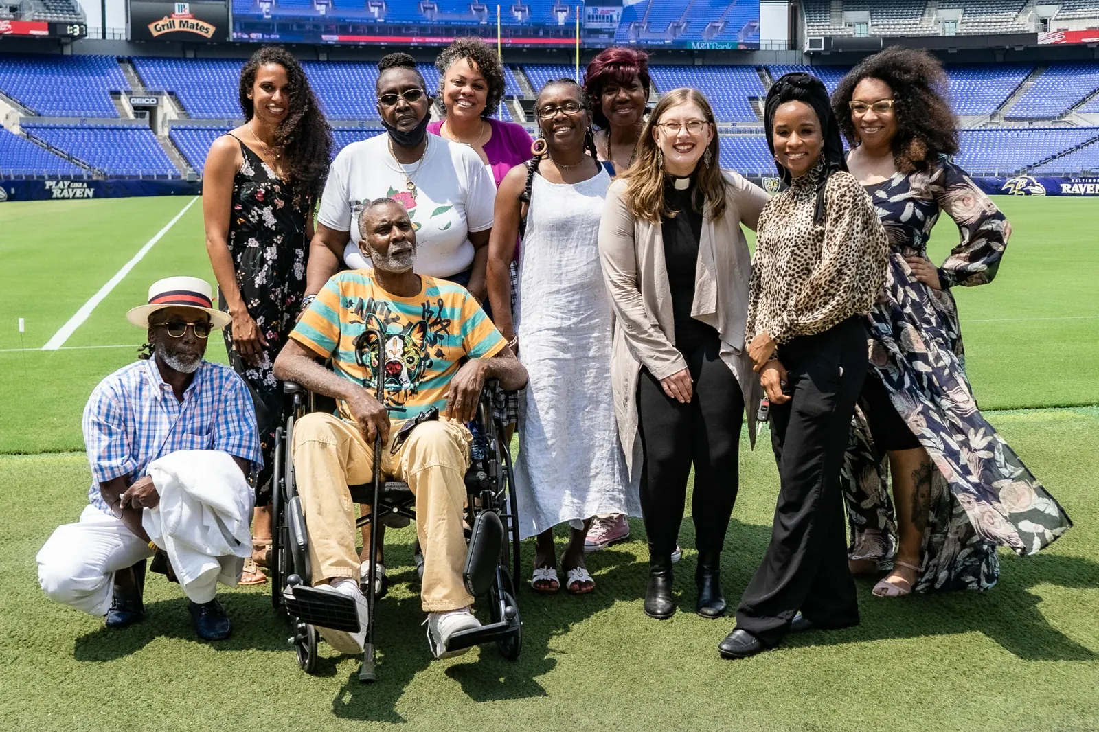 Weaver Awardees stand together on the green field of a football stadium.