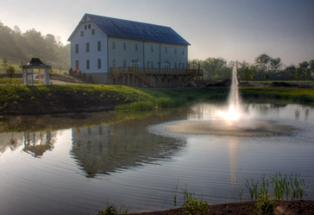 The barn and its gazebo across the pond at dawn, the fountain running.