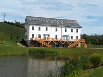 Muhlhauser Barn, white with its name across the roof, above the pond and its deck.