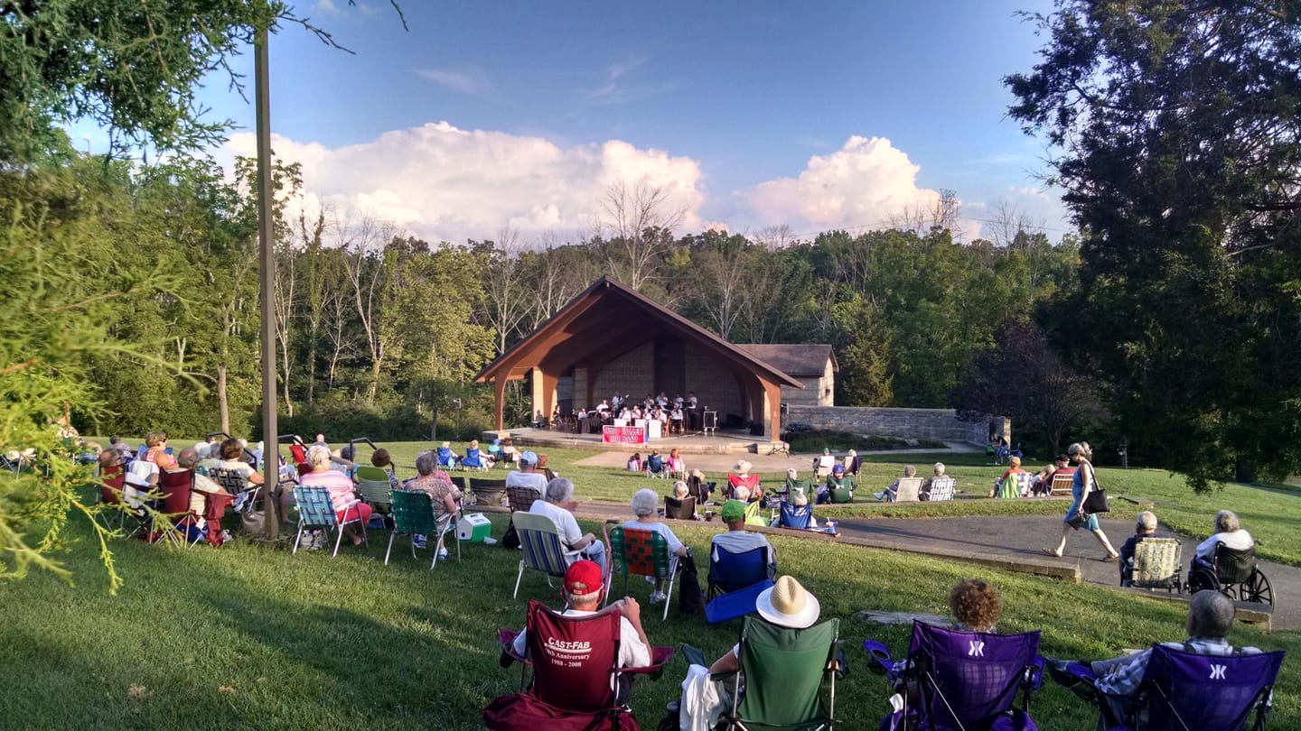 Residents sit on the lawn facing the wooden amphitheatre during a summer concert at Keehner Park.