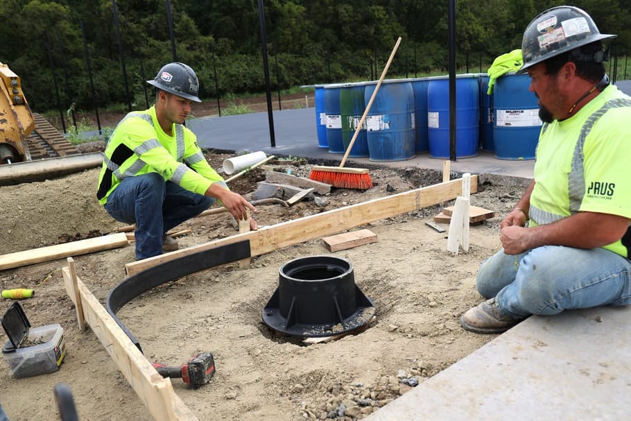 Prus Construction workers discuss a concrete form at the Beckett Park courts.